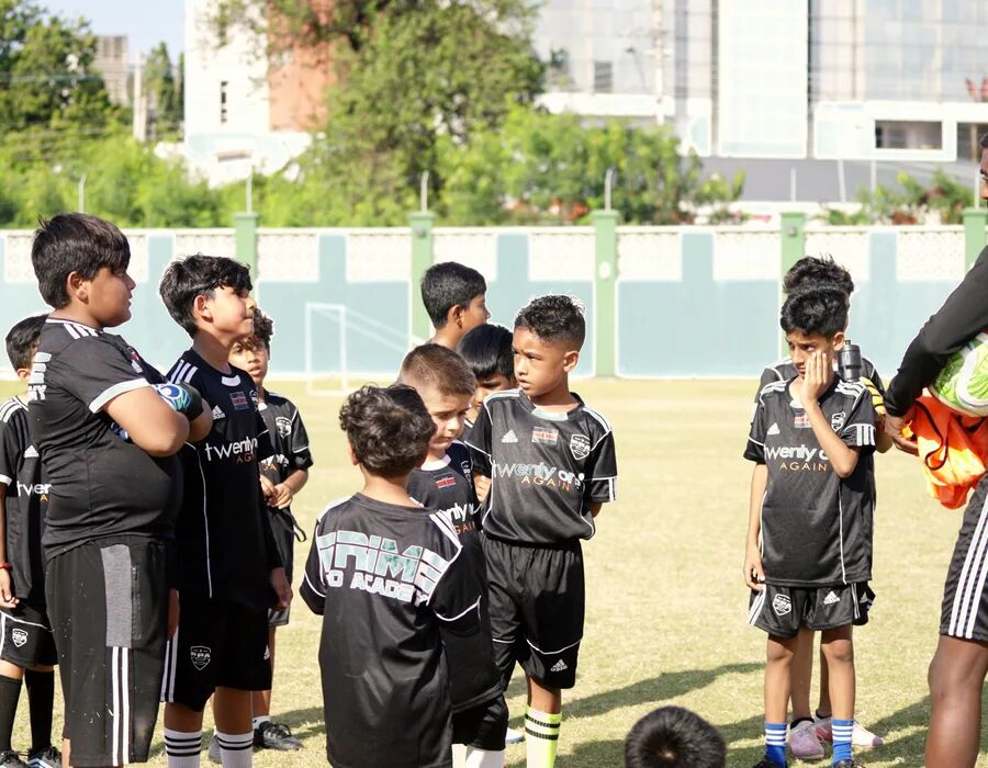 Coach and players in a huddle at training
