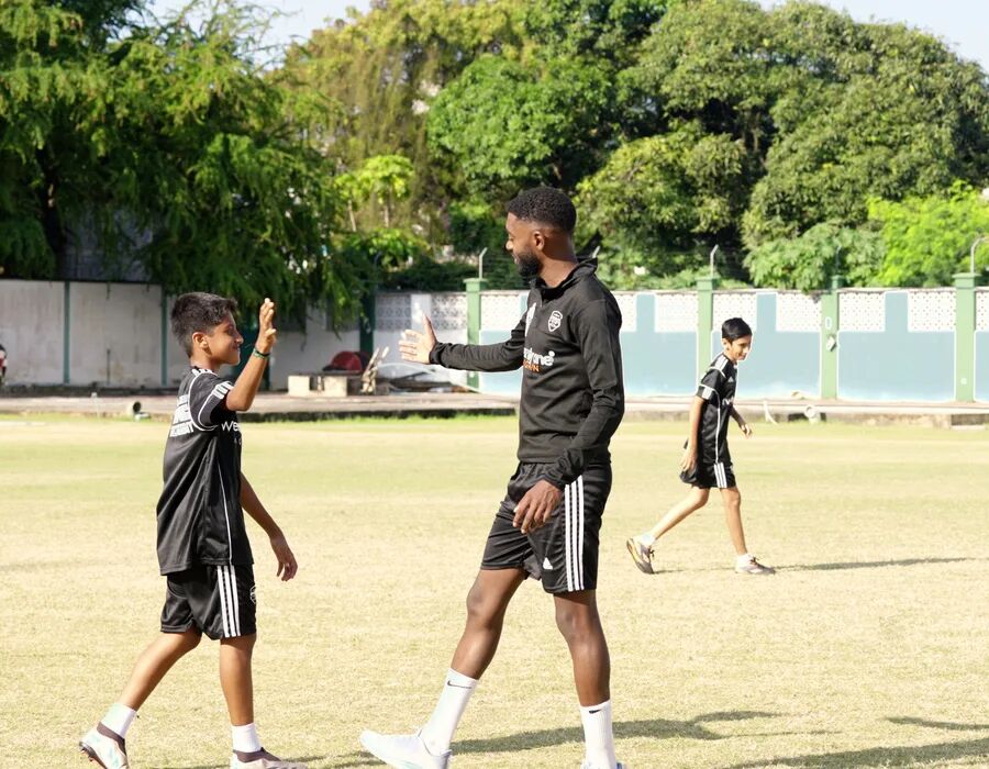 A coach leading a session on the pitch
